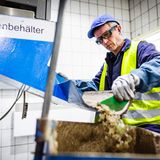 Weiterverarbeitung in der Glashütte: Ein Scherbeneingangskontrolleur entnimmt aus der Lieferung eine 50 Kilogramm schwere Probe und prüft die Qualität des Rohstoffs.