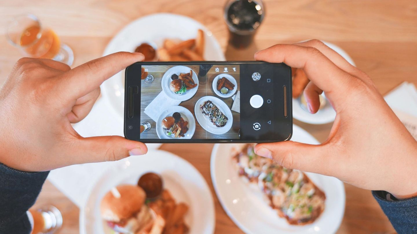 Jemand fotografiert mit seinem Handy sein Essen