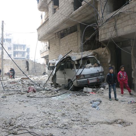 Syrien, Ost-Ghuta: Zwei Kinder gehen an zerstörten Häusern vorbei