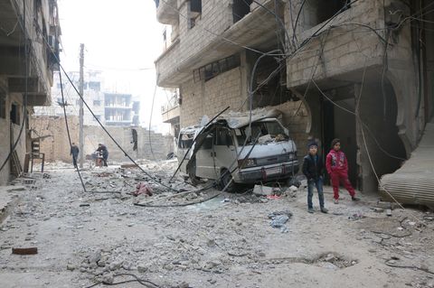 Syrien, Ost-Ghuta: Zwei Kinder gehen an zerstörten Häusern vorbei