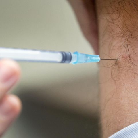 Ein Mann wird gegen Grippe geimpft
