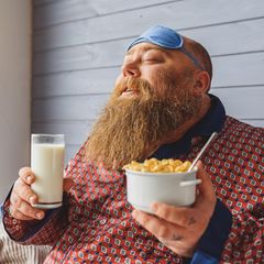 Mann genießt am Morgen seine Cornflakes