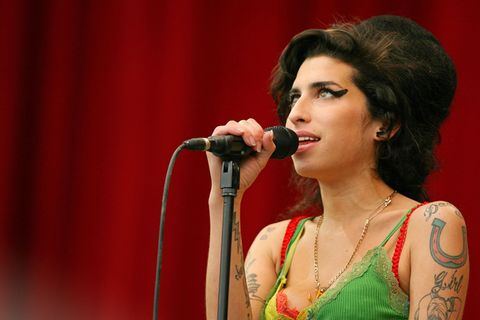Amy Winehouse steht am Mikrofon und singt