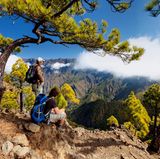 La Palma  Morgens im Norden der Isla Bonita, der "schönen Insel". Wer ein Stück weit oben wohnt, kann sehen, wie die Strahlen der Sonne langsam den Morgennebel aus der Caldera de Taburiente vertreiben, jenem gewaltigen Krater, der wirkt, als ob ihn ein vorzeitlicher Gigant voller Wut in das Gestein geschlagen hätte. Man kann die Caldera durch den Barranco de Las Angustias, die Schlucht der Ängste, durchwandern. Ein Erlebnis. Die ganze Insel ist ein Traum. Gerade für Wanderer: die Ausblicke spektakulär, die Vegetation üppig. Man findet jahrhundertealte, mächtige Drachenbäume, wandert durch den märchenhaften Dschungel des Biosphärenreservats von Los Tilos oder durch die 13 Tunnel von Marcos y Cordero zu malerischen Wasserfällen. Die Hauptstadt Santa Cruz lockt mit jahrhundertealter Architektur, der Ort Tazacorte mit einem schwarzen Sandstrand. Und abends nach der Wanderung dann ein kühles Bier in der "heimlichen Hauptstad" Los Llanos auf der Plaza de España unter Lorbeerbäumen. Wandererglück!  Hacienda San Jorge bei Santa Cruz: Die Anlage in unmittelbarer Meeres nähe hat Dorfcharakter. DZ/F ab ca. 100 Euro, www.hsanjorge.com