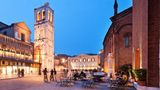 Ferrara  Dick und trutzig sitzt das Castello Estense in seinem Wassergraben in der Mitte der Stadt. Doch da kann sich die mittelalterliche Burg mit ihren Zugbrücken noch so aufspielen – die Hauptrolle in Ferrara spielt, wie überall in der Region Emilia-Romagna, das Essen. Die oberitalienische Stadt feiert besonders ihre Wurstund Aufschnittspezialitäten und ihre Pasta. Fast jedes Restaurant hat die ortstypischen Klassiker auf der Karte: Cappellacci di zucca, mit Kürbispüree gefüllte Nudeln, und Salama da sugo ferrarese, eine weiche, gekochte Salami, die zusammen mit cremigem Kartoffelbrei serviert wird. Eine empfehlenswerte Adresse, um die lokale Küche kennenzulernen, ist etwa die "Osteria i Quattro Angeli" direkt am Castello, hier sitzen mehr Ferraresi als Touristen. Wer sich das viele üppige Essen wieder abtrainieren will, fährt mit dem Fahrrad neun Kilometer entlang der alten Mauern rund um die Stadt, denn Ferrara ist auch eine der Städte mit der höchsten Fahrraddichte der Welt – und das ist eher ungewöhnlich im Vespaland Italien.  Dolcemela: Die komfortable und moderne Pension hat blitzsaubere, hübsche Zimmer und liegt in einer ruhigen Seitengasse im Zentrum. Gutes Frühstück, kostenlose Leihfahrräder. DZ/F ab 80 Euro, www.dolcemela.it