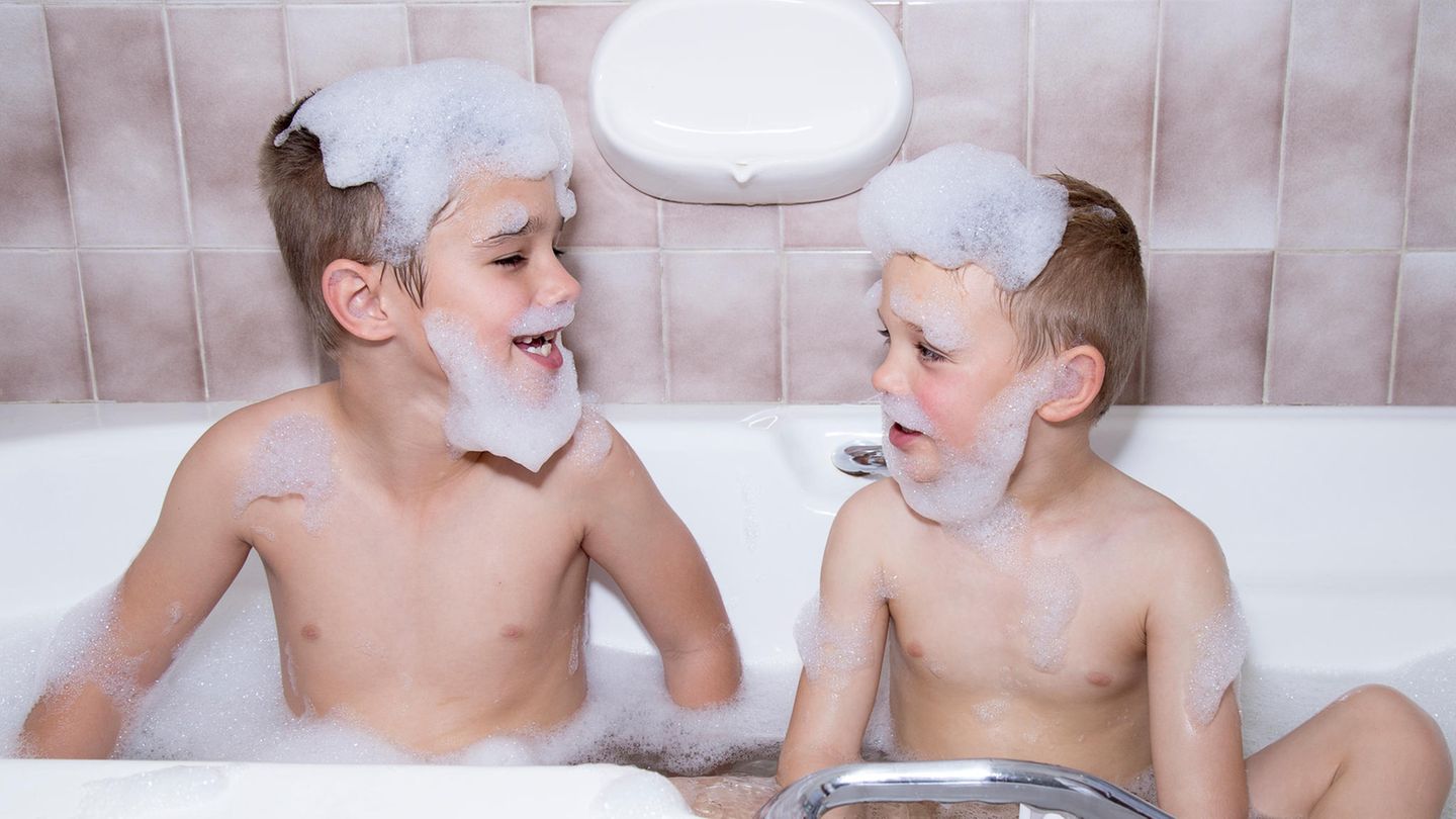 Zwei Jungen sitzen in einer Badewanne und gucken sich an