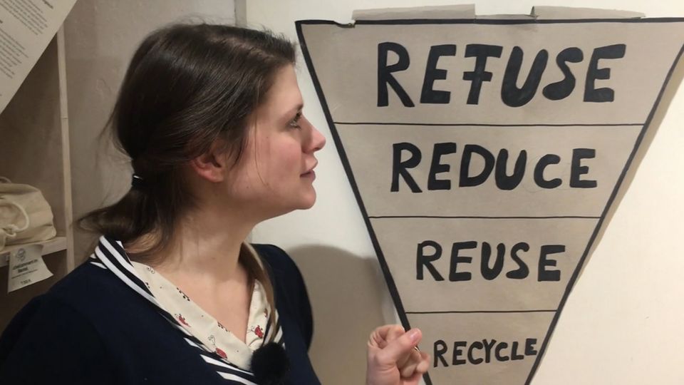 Frau mit einer Darstellung der fünf Prinzipien des Zero Waste Frau mit einer Darstellung der fünf Prinzipien des Zero Waste