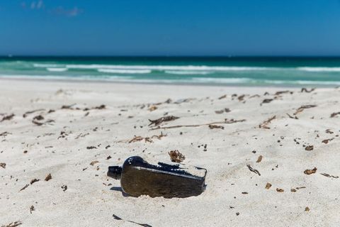 Eine Flasche liegt im Sand eines Strandes - Es soll sich um die deutsche Flaschenpost handeln, die nach 132 Jahren in Australien
