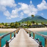 Nevis, Karibik: Ruhe und Old-School-Charme  Ohne All-Inklusive-Hotels oder Kreuzfahrtschiffe ist Nevis so erfrischend wie ein sanfter Passatwind. Die Unterkünfte sind oft historisch – alte Zuckerplantagen, die heute stimmungsvolle Hotels sind. Das Unterhaltungsprogramm: Tauchen, Wanderungen um den Nevis Peak und Rum-Schlurfen am Pinney’s Beach.