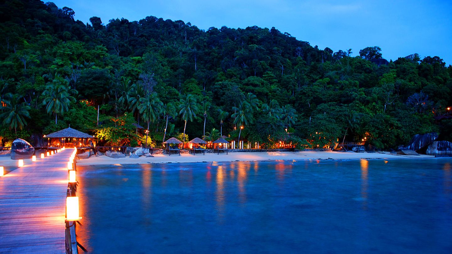 Tioman, Malaysia: Wasserfälle, lokales Leben, sensationellen Sand  Der Westen ist zwar am besten, wenn es um malaysische Strände geht, Pulau Tioman aber, 56 Kilometer vor der Ostküste der Halbinsel Malaysia im Südchinesischen Meer gelegen, hat ebenfalls einige der traumhaftesten zu bieten. Der feine Sand und das warme, kristallklare Wasser umrahmen ein urtümliches Binnenland mit Wasserfällen und Urwald und voller Abenteuer. Entspannte Fischerdörfer sorgen für lokales Flair.