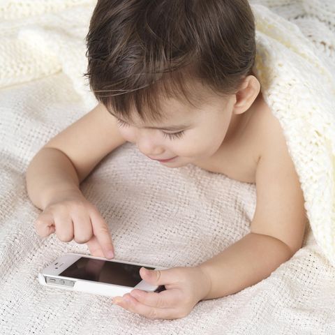 Ein Kleinkind tipp auf ein iPhone