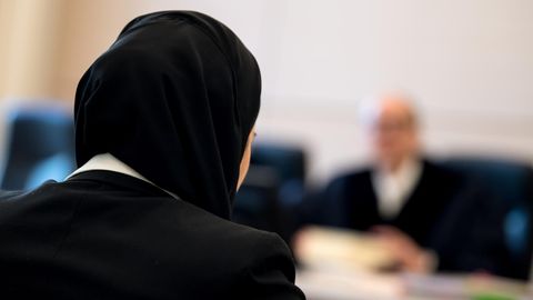 Die Jurastudentin Aqilah S. sitzt mit Kopftuch vor Verhandlungsbeginn im bayerischen Verwaltungsgerichtshof.