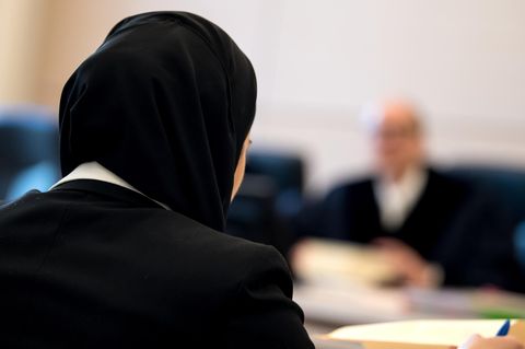 Die Jurastudentin Aqilah S. sitzt mit Kopftuch vor Verhandlungsbeginn im bayerischen Verwaltungsgerichtshof.