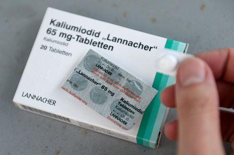 Auf einer weißen Schachtel mit dünnem grünen Rand liegt ein Blister mit sechs Jodtabletten