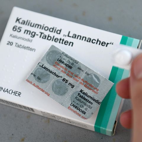 Auf einer weißen Schachtel mit dünnem grünen Rand liegt ein Blister mit sechs Jodtabletten