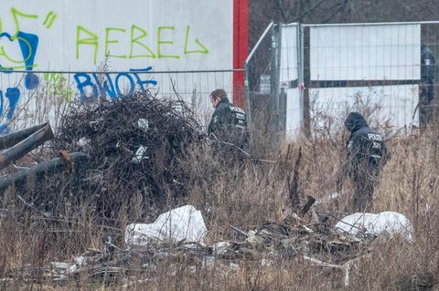 Polizisten durchsuchen ein Baugrundstück in Berlin Alt-Hohenschönhausen