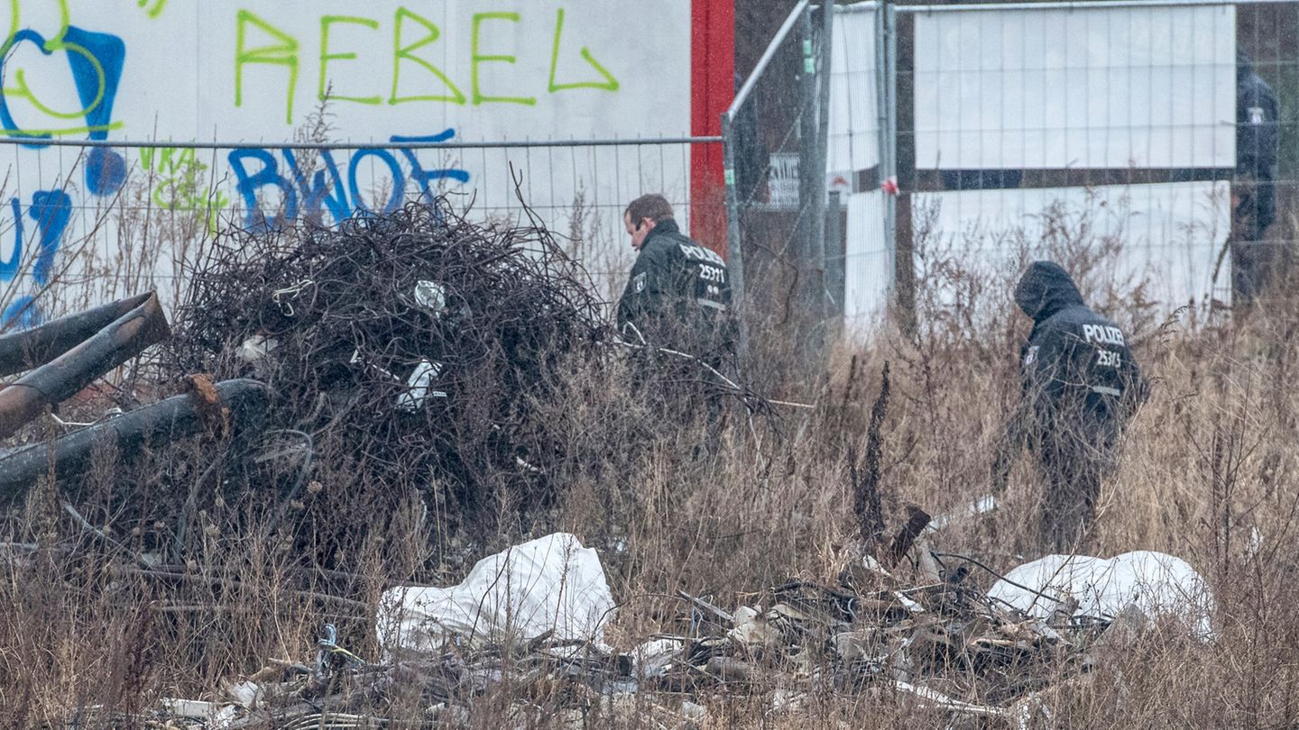 Polizisten durchsuchen ein Baugrundstück in Berlin Alt-Hohenschönhausen