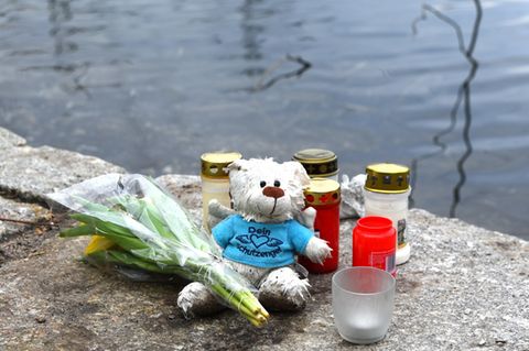 Blumen, Kerzen und ein Teddybär liegen am Weiher in Mannheim: Hier wurde im Januar ein totes Baby gefunden