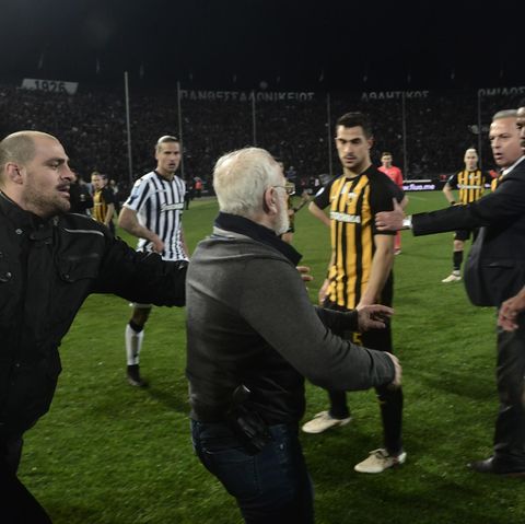 Ivan Savvidis (m.), Präsident von Paok Saloniki, läuft beim griechischen Derby zwischen Paok und AEK Athen mit einer Pistole am Gürtel aufs Spielfeld.
