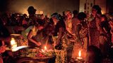 Frauen verkaufen Gemüse im Dorf Glo im Süden Benins. Die einzige Lichtquelle sind kleine Lampen mit teurem Petroleum: Die Menschen in Benin geben im Schnitt ein Fünftel ihres Einkommens für Licht aus