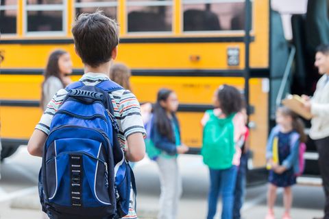 Kinder vor einem gelben Schulbus