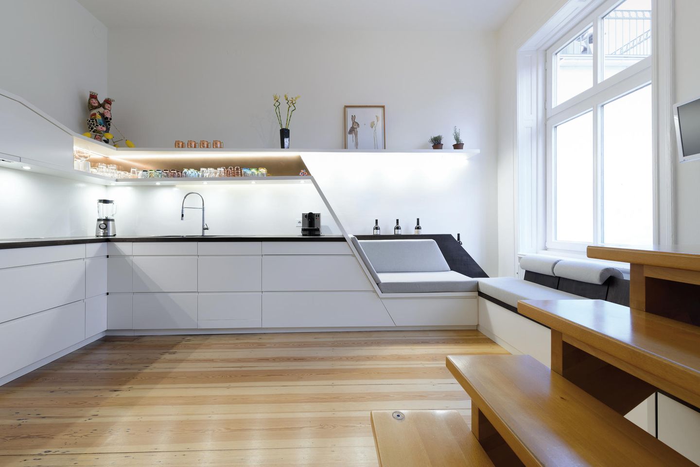 Die Sitzküche: Wer keinen Bedarf für eine Treppe hat, kann seine Küchenzeile in eine Sitzbank übergehen lassen.