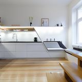 Die Sitzküche: Wer keinen Bedarf für eine Treppe hat, kann seine Küchenzeile in eine Sitzbank übergehen lassen.