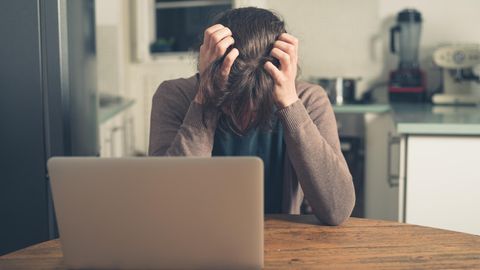 Eine Frau sitzt am Computer und ärgert sich über Crypto-Jacking