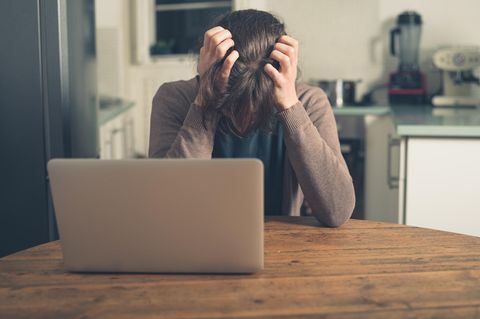 Eine Frau sitzt am Computer und ärgert sich über Crypto-Jacking