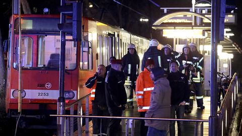 Feuerwehrleute stehen an der Haltestelle in der Kölner Innenstadt, an der zwei Straßenbahnen zusammengestoßen sind