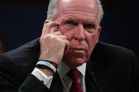 John O. Brennan, ein grauhaariger Mann in dunkelblauem Anzug und mit roter Krawatte, kratzt mit dem Finger seinen Augenwinkel