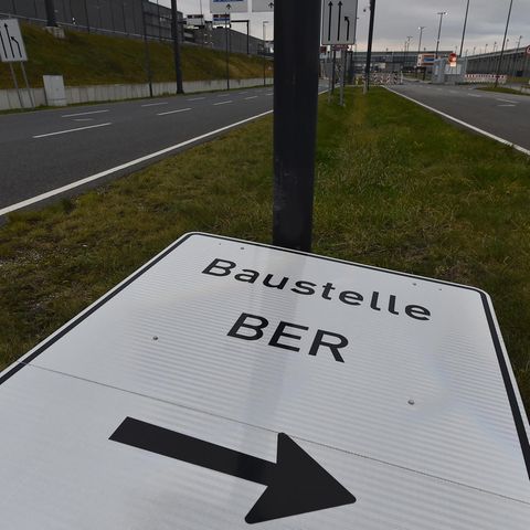 Umgekipptes Schild weist den Weg zur Baustelle des Flughafens Berlin Brandenburg
