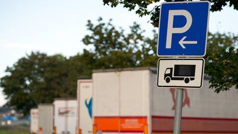 Geparkte Lastwagen stehen auf einem Autobahnrastplatz