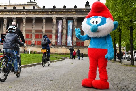 Papa-Schlumpf (Kostüm) steht auf einem Bürgersteig