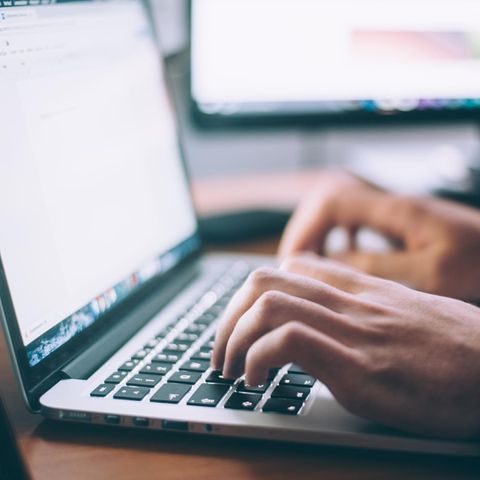 Hände tippen an einem Laptop