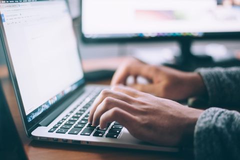 Hände tippen an einem Laptop