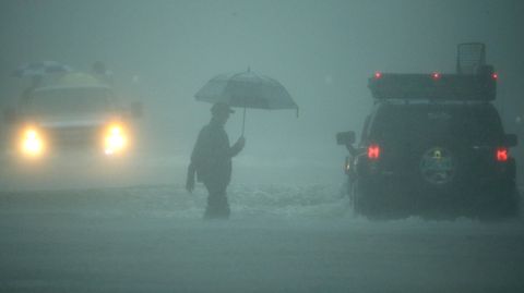 Ein Mann geht durch extremen Regen