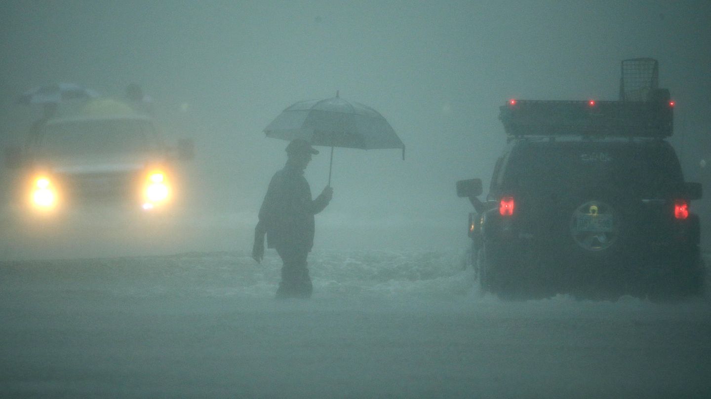 Ein Mann geht durch extremen Regen