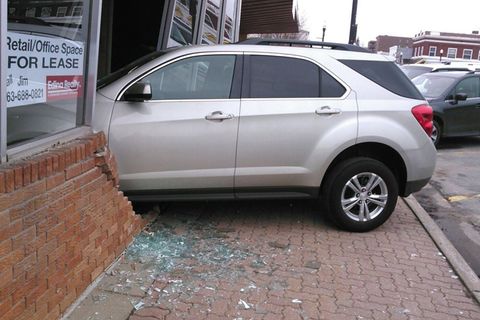 Ein Auto steht zu einem Drittel in einem Haus