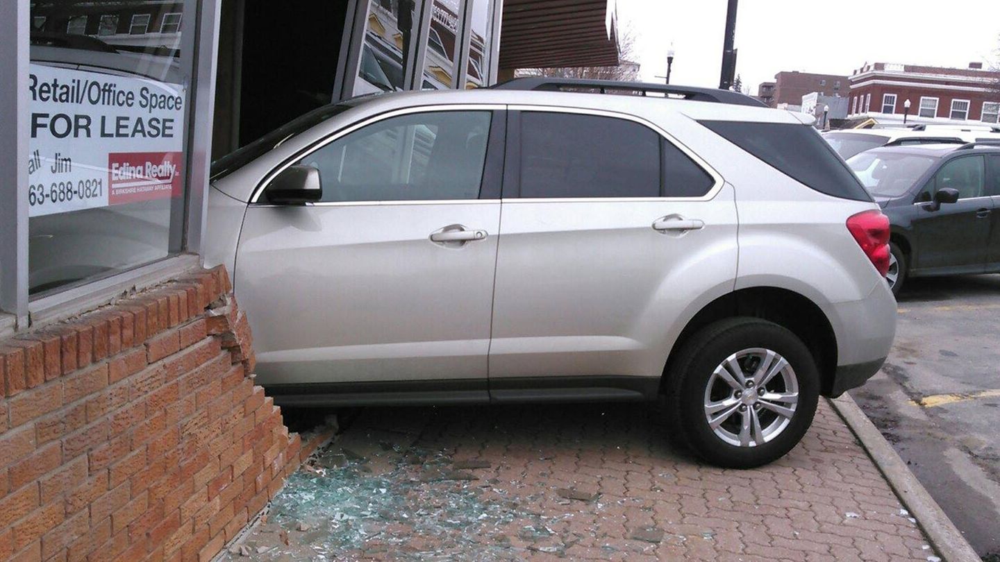 Ein Auto steht zu einem Drittel in einem Haus