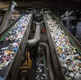Förderbänder transportieren den Verpackungsabfall in die eigentliche Sortierhalle, einem fast apokalyptischen Ort: dunkel, stickig, laut, klebrig, gefährlich.