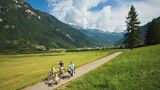 Auf zwei Rädern im Sattel  Fahrradfahren vor grandioser Kulisse: Im Trentino gibt es ein dichtes Wegenetz von Fahrradrouten. Dabei geht es mit dem Mountainbike nicht nur über Stock und Stein, sondern auch auf ausgeschilderten Wegen durch flache Täler - ohne Autoverkehr auf der Strecke, wie hier im Val di Fiemme.