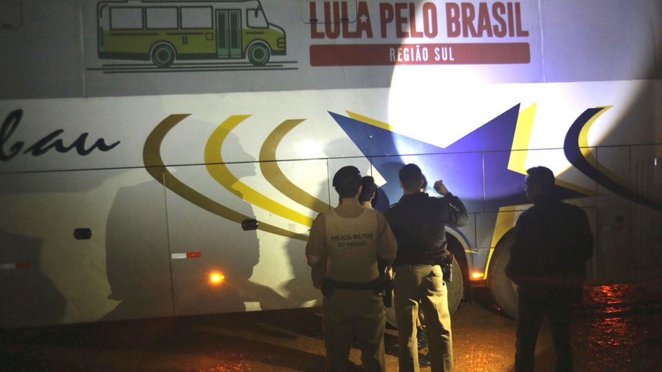 Polizisten untersuchen nach Schüssen auf die Fahrzeugkolonne von Ex-Präsident Luiz Inácio Lula da Silva einen Bus aus seinem Konvoi Polizisten untersuchen nach Schüssen auf die Fahrzeugkolonne von Ex-Präsident Luiz Inácio Lula da Silva einen Bus