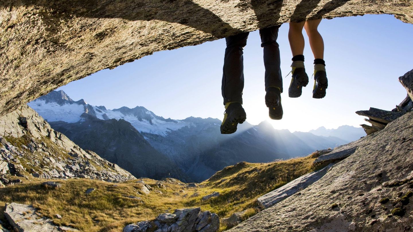 Zwei Wanderer gönnen sich eine Rast vor der Kulisse der Zillertaler Alpen.