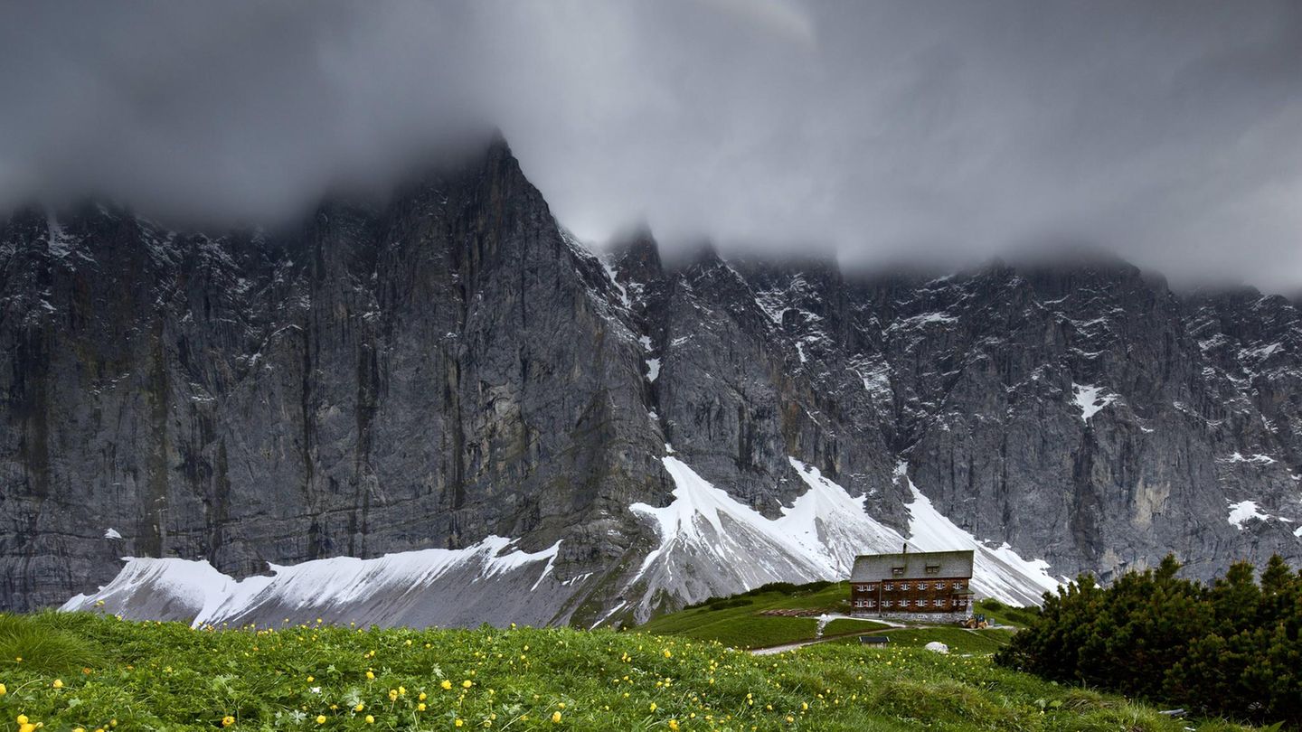 Ein Wettersturz hat Schnee in den graudunklen Laliderer Wänden oberhalb der Falkenhütte im Karwendel abgelagert.