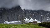 Ein Wettersturz hat Schnee in den graudunklen Laliderer Wänden oberhalb der Falkenhütte im Karwendel abgelagert.