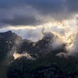 Vor der Kulisse der Allgäuer Alpen treiben Wolken ihr Windspiel – die Zuschauer verfolgen es von der Rappenseehütte aus.