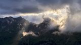 Vor der Kulisse der Allgäuer Alpen treiben Wolken ihr Windspiel – die Zuschauer verfolgen es von der Rappenseehütte aus.