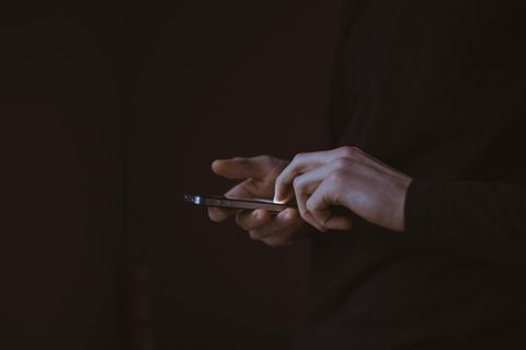 USA – ein Mann hält ein Handy in der Hand