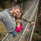Kleine familiäre Mutprobe  Ein zauberhaftes Tal, ein Wasserfall und dazwischen eine Hängebrücke in gut 60 Metern Höhe. Die schmale, rund 100 Meter lange Brücke im Val di Rabbi ist eine kleine Mutprobe. Wer sie wagt, bekommt eine herrliche Aussicht auf das Tal und den Wasserfall des Rio Ragaiolo. Für Hunde ist der luftige Spaziergang nichts. Die Lauffläche besteht aus Stahlgitter, das die Ballen der Vierbeine verletzen kann.  Vor dem Vergnügen wartet etwas Arbeit: Gute 30 Minuten ist man zu Fuß vom Parkplatz Rabi Fonti unterwegs.